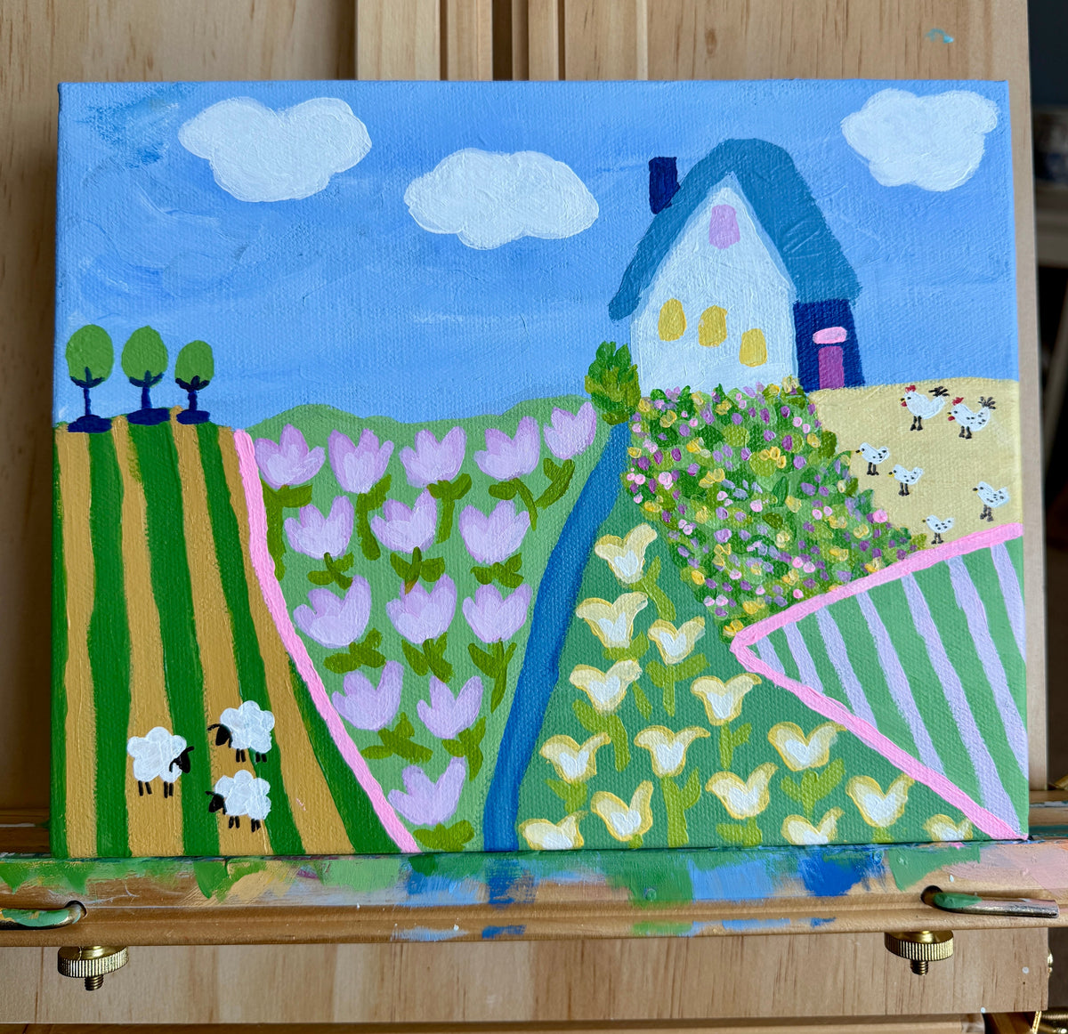Acrylic painting of a colorful farm landscape with tulip fields, sheep, and a white farmhouse by Minnesota artist Lori Friedrichs